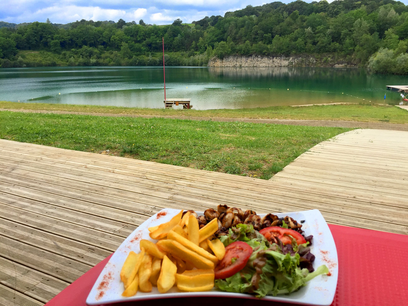 Assiette avec vue sur le lac de Guiche depuis la terrasse ombragée du snack de la Base de Pop